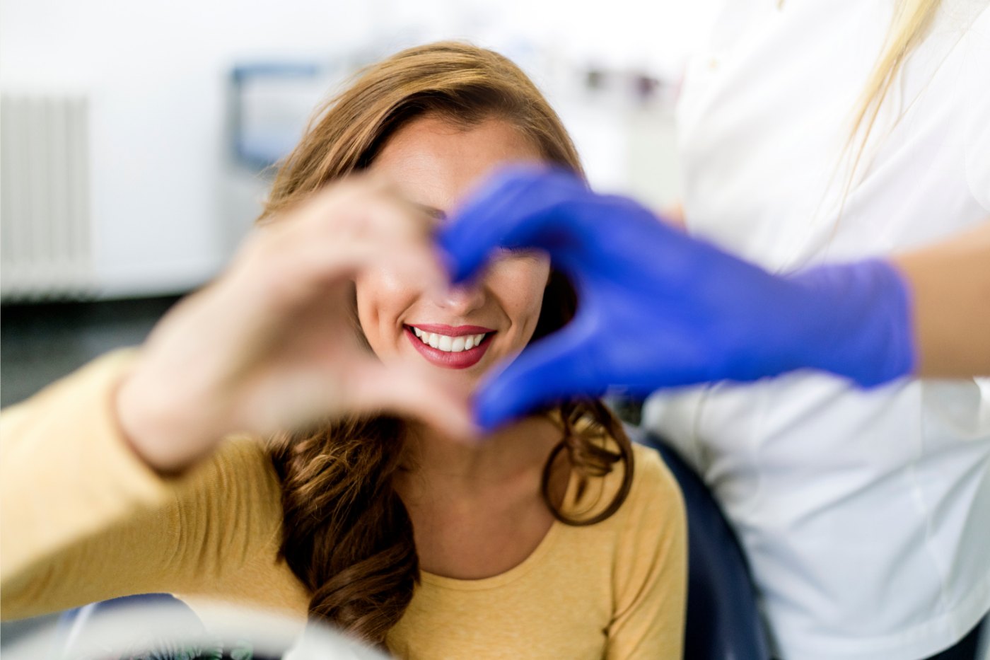 Paciente e dentista fazendo um coração com as mãos
